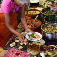 A woman serving herself from a table full of food