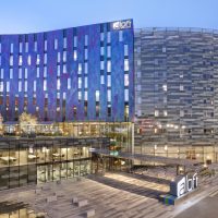 Aloft hotel exterior.  It looks like a blue wave made of glass