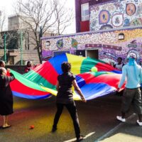 Children outside waving a colourful banner