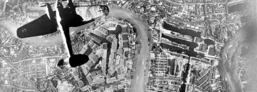 Old photo of a plane seen from above flying over the Thames